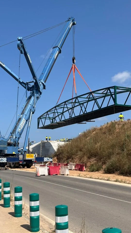 Excelencia estructural al servicio de la movilidad sostenible
Pasarela ciclopeatonal metálica – Faitanar (Valencia)
Con una estructura metálica de 40 metros de largo por 5 metros de ancho y un peso aproximado de 42 toneladas, esta nueva pasarela ciclopeatonal refuerza el compromiso con una movilidad más segura, eficiente y sostenible.
Diseñada, fabricada y montada íntegramente por Acople 2010, la estructura principal fue ejecutada con precisión milimétrica y un estricto control de calidad, reflejando nuestro firme compromiso con la seguridad, la durabilidad y la excelencia técnica.
 Montaje en tiempo récord:
El izado y colocación se realizaron el domingo 8 de junio de 2025, empleando medios propios y una planificación logística ejemplar, que permitió completar el montaje en una sola jornada, con una interrupción mínima del tráfico de apenas 40 minutos.
Este proyecto es un nuevo ejemplo de nuestra capacidad para abordar retos de gran envergadura, aportando soluciones estructurales de alto nivel para la obra civil y la conectividad urbana.
34 964 535 761 ✉️ acople@acople2010.com 🌐 www.acople2010.com 📍 C/ Vall d'Alba 15, 12550 Almazora, Castellón 🏗️ Especialistas en puentes, pasarelas y estructuras metálicas para obra civil e industria. #Acople2010 #PasarelasMetálicas #ObraCivil #Conectividad #MovilidadSostenible #ExcelenciaIndustrial #estructurametálica